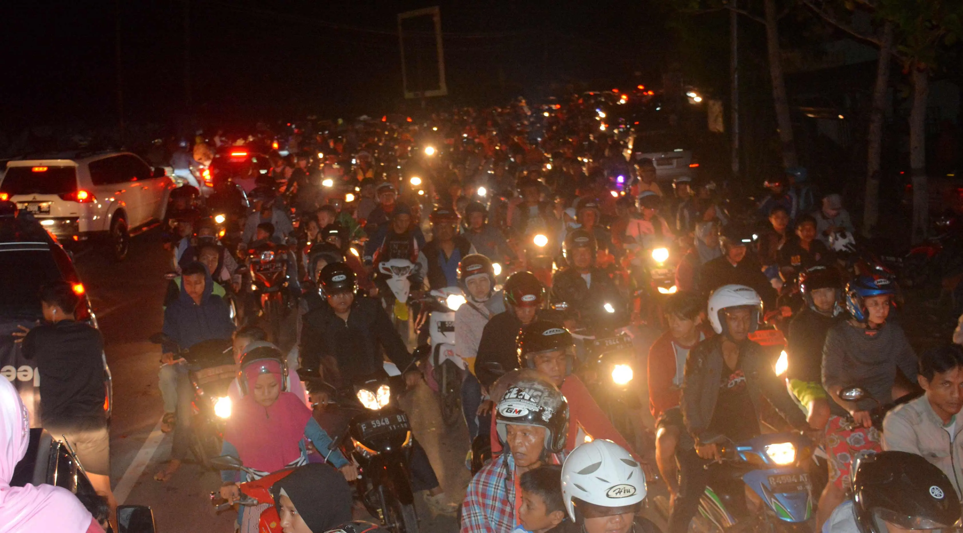 Sejumlah warga mengendarai motor mengungsi ke tempat yang lebih tinggi menyusul terjadinya gempa di Cilacap, Jawa Tengah (16/12). Gempa kuat yang mengguncang Pulau Jawa memicu peringatan akan terjadinya tsunami. (AP Photo / Wagino)