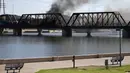 Kereta barang tergelincir dan terbakar di jembatan Danau Kota Tempe, Arizona, Amerika Serikat, Rabu (29/7/2020). Kecelakaan memicu kebakaran hebat dan terlihat beberapa kilometer. (AP Photo/Ross D. Franklin)