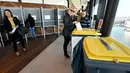 Warga memasukkan surat suara ke tempat sampah yang disulap menjadi kotak suara saat pemilihan umum Belanda di sebuah TPS di Menara A'Dam, Amsterdam, Rabu (15/3). Pemilu ini untuk menentukan siapa perdana menteri Belanda selanjutnya (AP Photo/Patrick Post)