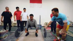 Menpora Imam Nahrawi (keempat kiri) bersiap melakukan angkatan saat meninjau kesiapan akhir atlet angkat besi di PB PABBSI, Jakarta, Selasa (21/6). Tujuh atlet angkat besi akan berlaga di Olimpiade Rio 2016. (Liputan6.com/Helmi Fithriansyah)
