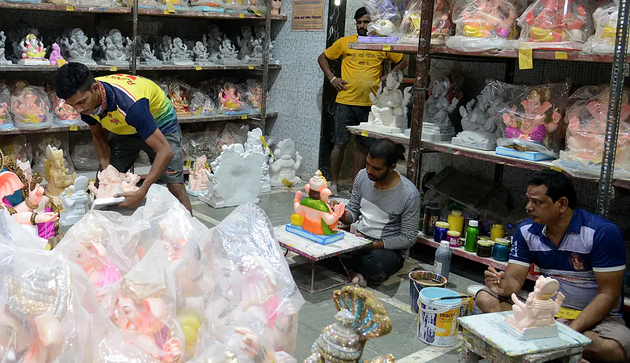 Seorang perajin memberikan sentuhan terakhir saat pembuatan patung Dewa Ganesha di sebuah bengkel di Mumbai, India, 24 Agustus 2021. Pembuatan patung dewa Hindu berkepala gajah tersebut dilakukan jelang Festival Ganesh Chaturthi. (SUJIT JAISWAL/AFP)