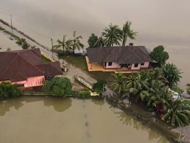 Foto udara menunjukkan dua rumah yang dikelilingi oleh banjir setelah hujan lebat di Kota Bharu, negara bagian Kelantan, Malaysia pada tanggal 1 Desember 2024. (MOHD RASFAN/AFP)