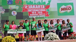 Wagub DKI Djarot Saiful (keempat kiri) dan juara Jakarta International 10K 2015 kategori elit putri nasional, Yulianingsih (kedua kanan) berfoto bersama seusai penyerahan hadiah di Silang Monas,  Jakarta, Minggu (31/5). (Liputan6.com/Helmi Afandi)