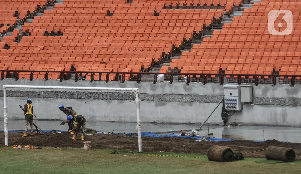 Aktivitas pekerja menyelesaikan pemasangan rumput lapangan utama Jakarta Internasional Stadium (JIS), Papanggo, Jakarta Utara, Selasa (11/1/2022). Progres pembangunan stadion terbesar di Asia yang dirancang sesuai standar FIFA tersebut saat ini mencapai 93,85 persen. (merdeka.com/Iqbal S. Nugroho)