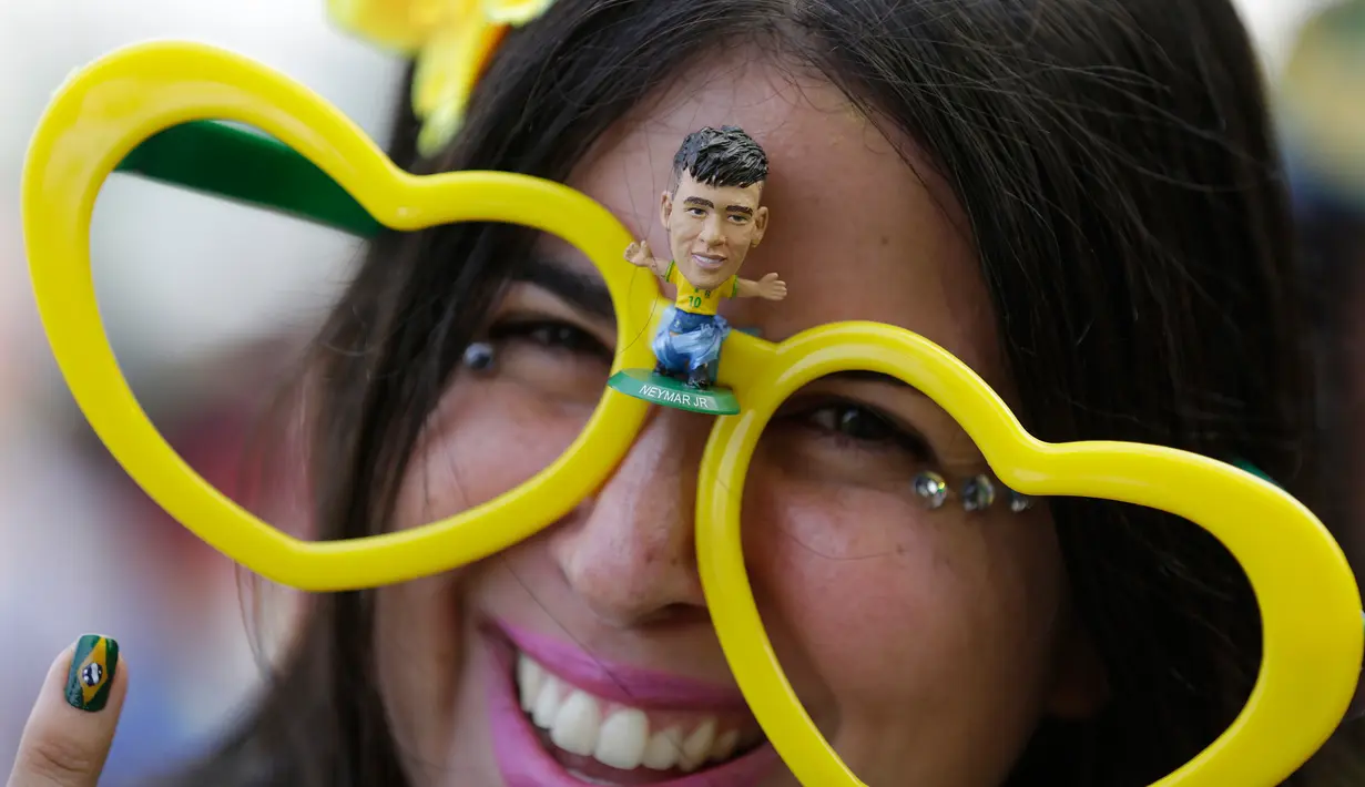 Suporter Brasil mengenakan kacamata dengan gambar pesepakbola Neymar sebelum laga terakhir penyisihan grup E Piala Dunia 2018 melawan Serbia di Rio de Janeiro, Rabu (27/6). Brasil sukses melaju ke babak 16 besar usai menang 2-0 (AP Photo/Silvia Izquierdo)