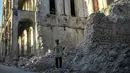 Seorang pria berdiri di dekat puing-puing bangunan yang runtuh di Jeremie, Haiti, empat hari setelah kota itu diguncang gempa berkekuatan 7,2 pada Rabu (18/8/2021). Korban jiwa akibat gempa bumi dahsyat yang melanda Haiti Sabtu pekan lalu terus bertambah menjadi 1.941 orang.  (AP/Matias Delacroix)