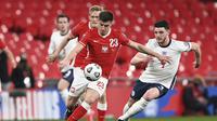 Striker Polandia, Krzysztof Piatek (kiri) menguasai bola dibayangi bek Inggris, Declan Rice dalam laga lanjutan Kualifikasi Piala Dunia 2022 Zona Eropa Grup I di Wembley Stadium, London, Rabu (31/3/2021). Polandia kalah 1-2 dari Inggris. (AP/Andy Rain)
