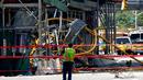 Seorang pekerja melihat ke atas di lokasi kebakaran dan runtuhnya derek konstruksi di New York, pada Rabu (26/7/2023). Dua belas orang, termasuk sembilan warga sipil dan tiga petugas pemadam kebakaran, semuanya menderita luka-luka yang tidak mengancam jiwa setelah sebuah derek jatuh di New York City pada hari Rabu. (Kena Betancur / AFP)