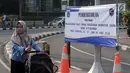 Warga melintasi spanduk pemberitahuan peniadaan pelaksanaan Hari Bebas Kendaraan Bermotor (HBKB) di sekitar Bundaran Hotel Indonesia, Jakarta, Minggu (3/6). Pelaksanaan HBKB akan ditiadakan pada 10, 17, dan 24 Juni 2018. (Liputan6.com/Helmi Fithriansyah)
