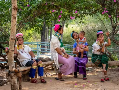 Perempuan Suku Kayan menunggu turis di luar kios suvenir mereka di Taman Chang Siam, Pattaya, Thailand, Rabu (12/2/2020). Chang Siam Park adalah salah satu primadona bagi wisatawan China di Pattaya  yang kini berangsur sepi karena penyebaran virus corona covid-19. (Mladen ANTONOV / AFP)