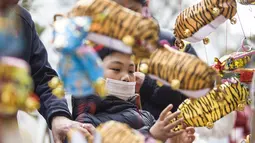 Seorang anak melihat lentera menjelang Festival Lampion, yang jatuh pada 15 Februari tahun ini - hari ke-15 Tahun Baru Imlek - di Nanjing di provinsi Jiangsu timur China pada 10 Februari 2022. Festival Lampion merupakan puncak sekaligus penutup dari perayaan Tahun Baru Imlek. (STR / AFP)