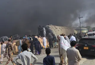 Tentara paramiliter dan para relawan mengevakuasi korban dari gerbong kereta yang terbalik di jalur rel di lokasi ledakan bom, di Quetta, Pakistan, Minggu, 24 Mei 2026. (AP Photo/Arshad Butt)