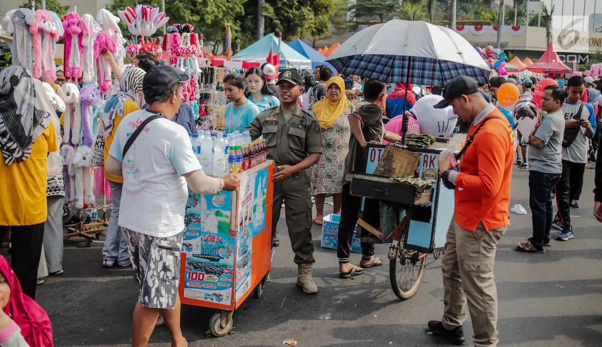 Petugas Satpol PP menertibkan PKL di kawasan car free day (CFD), Bundaran HI, Jakarta, Minggu (4/8/2019). Penertiban dilakukan karena keberadaan PKL membuat tidak nyaman pengunjung CFD yang ingin berolahraga, berorasi, atau sekadar jalan-jalan. (Liputan6.com/Faizal Fanani)
