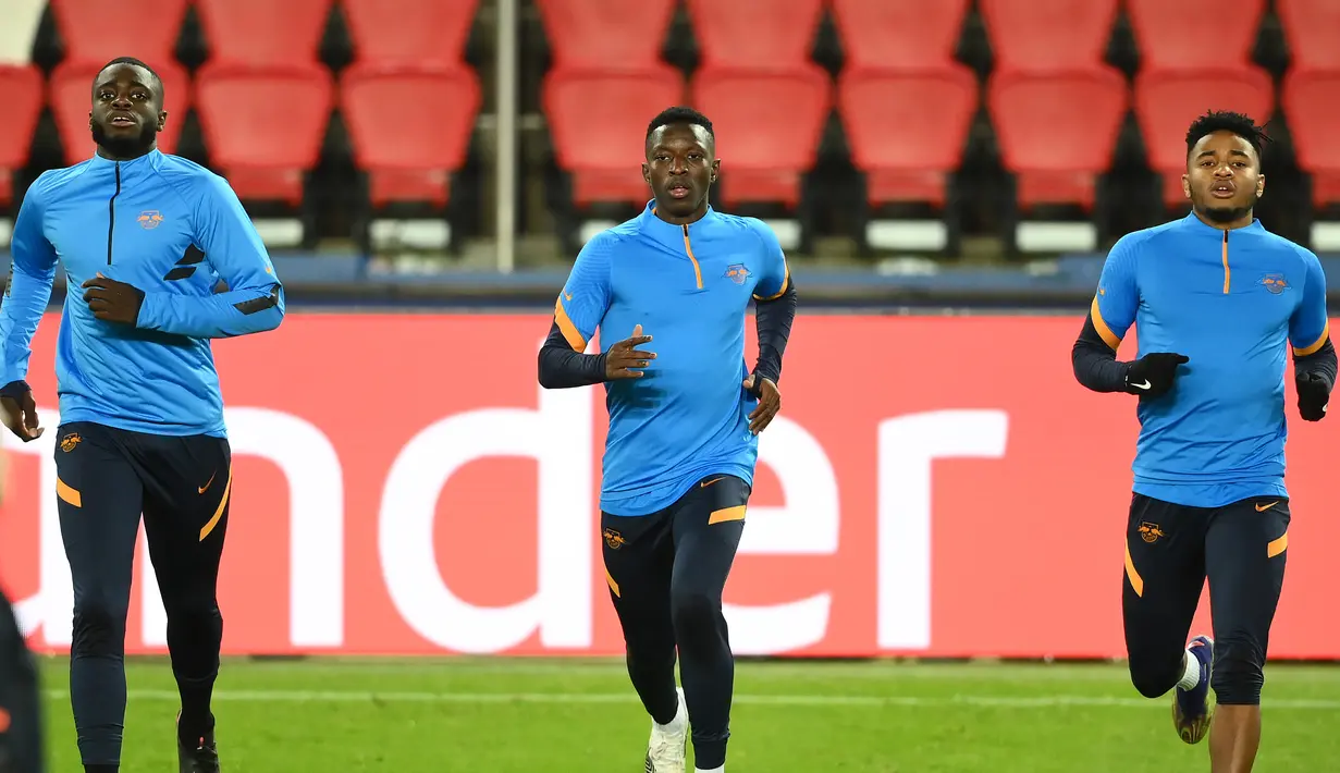 Bek RB Leipzig, Dayot Upamecano (Kiri) dan gelandang Christopher Nkunku melakukan pemanasan saat mengikuti sesi latihan di stadion Parc des Princes di Paris (23/11/2020). Leipzig akan bertanding melawan PSG pada Grup H Liga Champions. (AFP/Franck Fife)