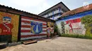Dua anak bermain di samping sisi tembok warga yang dindingnya dihiasi lukisan mural penuh warna di Kampung Pejaten, Jakarta, Senin (30/4). Mural motif warna-warni itu digagas warga untuk memperindah kampung mereka. (Liputan6.com/Herman Zakharia)