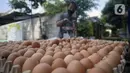 Pedagang menimbang telur saat melayani pembeli di pinggir jalan kasawan Perumahan Nusa Indah, Tangerang Selatan, Banten, Jumat (22/5/2020). Harga telur warna cokelat Rp 22 ribu per kilogram, sedangkan telur warna putih Rp 20 ribu per kilogram. (merdeka.com/Dwi Narwoko)