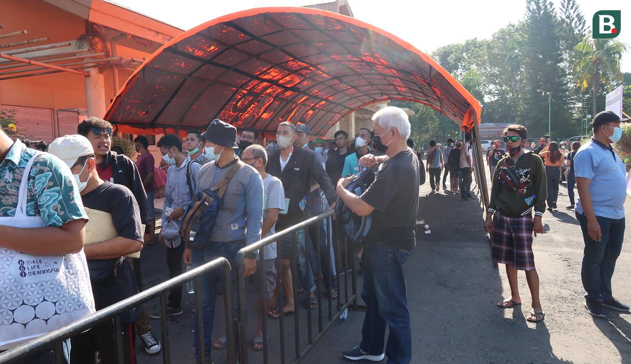 Banyaknya calon penonton yang mengantri membuat satgas Covid-19 di lokasi terus mengingatkan untuk selalu mentaati protokol kesehatan. (Bola.com/Ade Yusuf Satria)