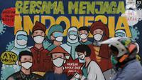 Pengendara melintas di depan mural protokol kesehatan COVID-19 di Jakarta, Minggu (21/11/2021). Untuk mencegah lonjakan kasus Covid-19, pemerintah akan menerapkan kebijakan PPKM Level 3 untuk seluruh wilayah Indonesia selama masa libur Natal 2021 dan Tahun Baru 2022.(Liputan6.com/Helmi Fithriansyah)