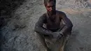 Pekerja India Suleiman, 36 tubuhnya terkena tanah saat beristirahat di sebuah pabrik batu bata di pinggiran Gauhati, India (22/11). Sebagian besar buruh di sini mendapatkan Rupee 120 (kurang dari 2 Dolar) per hari. (AP Photo/Anupam Nath)