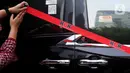 Petugas Komisi Pemberantasan Korupsi (KPK) memasang garis pembatas di samping mobil Alphard hasil sitaan penggeledahan rumah dinas Wakil Menteri Ketenagakerjaan (Wamenaker) Immanuel Ebenezer di kawasan Pancoran, Jakarta Selatan, Selasa (26/8/2025). (Liputan6.com/Helmi Fithriansyah)