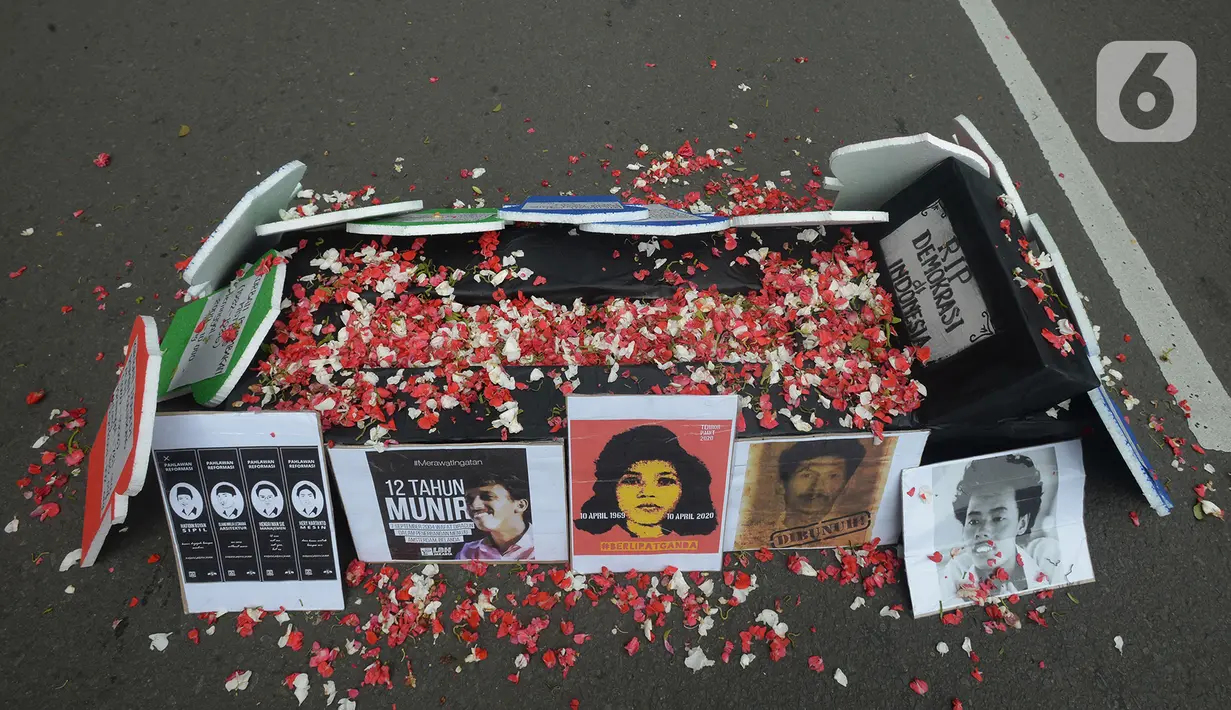 Aksi tabur bunga berbagai elemen saat unjuk rasa memperingati Hari HAM Sedunia di Patung Kuda, Jakarta, Kamis (10/12/2020). Standar HAM diharapkan mampu diterapkan untuk mengatasi ketidaksetaraan, pengucilan, dan diskriminasi yang mengakar, sistematis, dan antargenerasi. (merdeka.com/Imam Buhori)