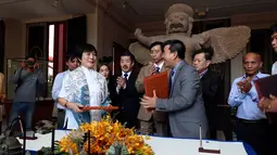 Kolektor Jepang Fumiko Takakuwa (kiri) menyerahkan sejumlah artefak di Museum Nasional, Phnom Penh, Kamboja, Jumat (5/7/2019). Sebelumnya, Fumiko Takakuwa telah memajang sejumlah artefak asal Kamboja selama dua dekade di rumhanya. (AP Photo/Heng Sinith)
