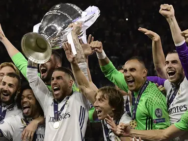 Kapten Real Madrid, Sergio Ramos, mengangkat piala merayakan gelar juara Liga Champions bersama rekan-rekannya di Stadion Millenium, Cardiff, Sabtu (3/6/2017). Madrid menang 4-1 atas Juventus. (AFP/Javier Soriano)