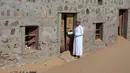Mantan penduduk Wadi al-Murr, Mohammed al-Ghanbousi berdiri di samping rumahnya yang ditinggalkan di Desa Omani, Wadi al-Murr, Oman, 31 Desember 2020. Penduduk Wadi al-Murr  yang meninggalkan desanya meningkatkan jumlah mereka yang bermigrasi ke kota-kota. (MOHAMMED MAHJOUB/AFP)