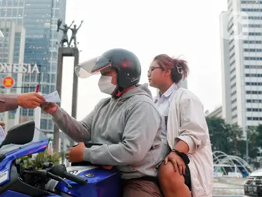 Polisi melakukan penindakan sanksi tilang kepada pengendara motor yang melakukan pelanggaran di Bundaran Hotel Indonesia (HI), Jakarta, Senin (15/5/2023). (Liputan6.com/Angga Yuniar)