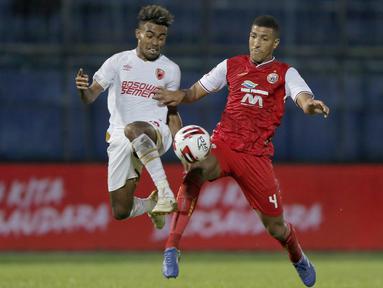Pemain Persija Jakarta, Yann Motta Pinto (kanan), berebut bola dengan pemain PSM Makassar, Yakob Sayuri, dalam pertandingan Babak Penyisihan Piala Menpora 2021 di Stadion Kanjuruhan, Malang. Senin (22/3/2021). (Bola.com/Arief Bagus)