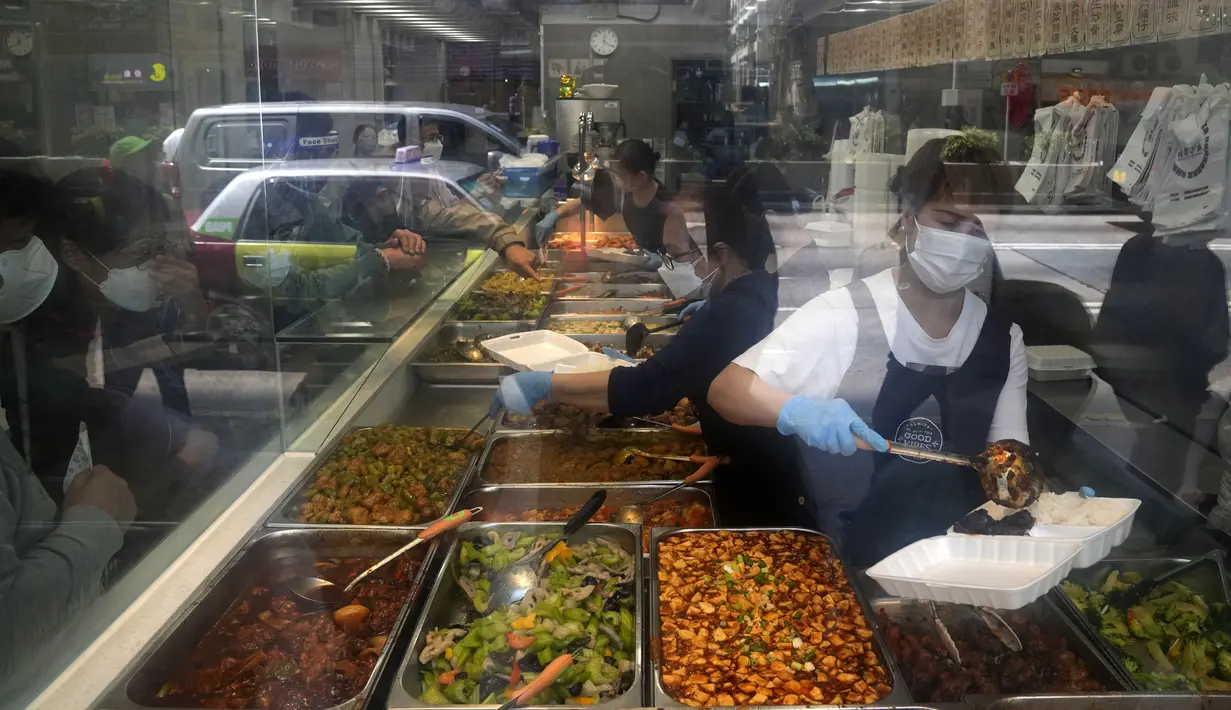 Pekerja yang memakai masker menyiapkan kotak makan siang untuk pesanan take away di sebuah restoran di Hong Kong, Jumat (4/3/2022). Pemimpin Hong Kong awal pekan ini mengatakan mobilitas orang mungkin dibatasi selama tes covid-19 massal wajib ketika kasus harian mencapai rekor. (AP Photo/Kin Cheung)