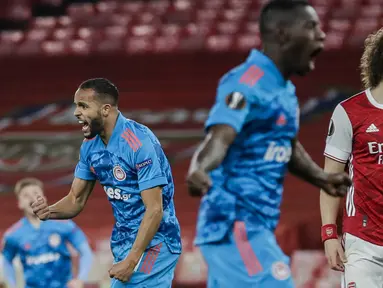 Striker Olympiakos, Youssef El-Arabi (kiri) melakukan selebrasi usai mencetak gol ke gawang Arsenal dalam laga leg kedua babak 16 besar Liga Europa 2020/2021 di Emirates Stadium, London, Kamis (18/3/2021). Olympiakos menang 1-0 atas Arsenal. (AP/Matt Dunham)