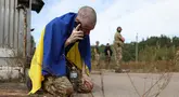 Seorang prajurit Ukraina menelepon setelah dibebaskan dari tawanan Rusia di sebuah lokasi yang dirahasiakan di dekat perbatasan Ukraina-Belarusia, pada 13 September 2024. (Anatolii STEPANOV/AFP)