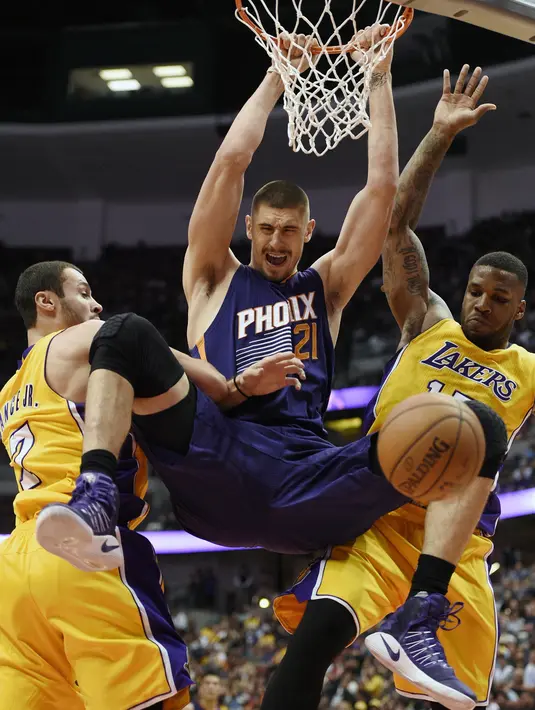 Aksi pemain Phoenix Suns, Alex Len, (tengah) saat melakukan dunk ditengah hadangan dua pemain Los Angeles Lakers pada laga NBA preseason basketball game di Anaheim, California (22/10/2016). (AP/Kelvin Kuo)