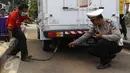 Petugas dan polisi saat melakukan pengujian emisi di jalan Juanda Depok, Jawa Barat, (4/11/2015). Sejumlah kendaraan diberhentikan oleh petugas gabungan dari Unit lantas Polres Kota Depok serta Dinas perhubungan Kota Depok. (Liputan6.com/Yoppy Renato)
