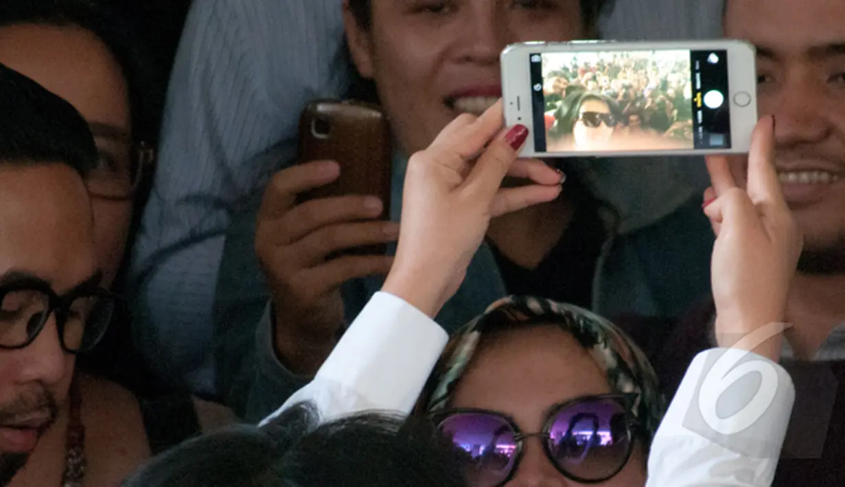 Syahrini berfoto selfie usai menjawab pertanyaan wartawan di Bareskrim, Jakarta, Senin (2/3/2015). Ia diperiksa terkait kasus Ketua KPK nonaktif Abraham Samad dan Feriyani Lim. (Liputan6.com/Yoppy Renato)