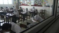 Sejumlah siswa dengan serius menyelesaikan soal saat Utusan Komite III DPD Emma Yohanna memantau pelaksanaan UN pada hari pertama di SMA 1 Padang, Sumbar. (Antara)