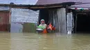 Seorang wanita membawa peralatan rumah tangga saat meninggalkan rumahnya yang terendam banjir di Sunamganj, Bangladesh, Minggu (12/7/2020). Banjir di sejumlah wilayah Bangladesh telah memengaruhi kehidupan lebih dari 1,3 juta orang dan mengakibatkan puluhan ribu keluarga mengungsi. (Xinhua)