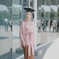 Saat wisuda, selebgram Dwi Handayani memilih kebaya dusty pink dengan bordir bunga dan pita. Jarik batik serta hijab yang senada, menyempurnakan tampilannya. (Instagram/dwihandaanda).