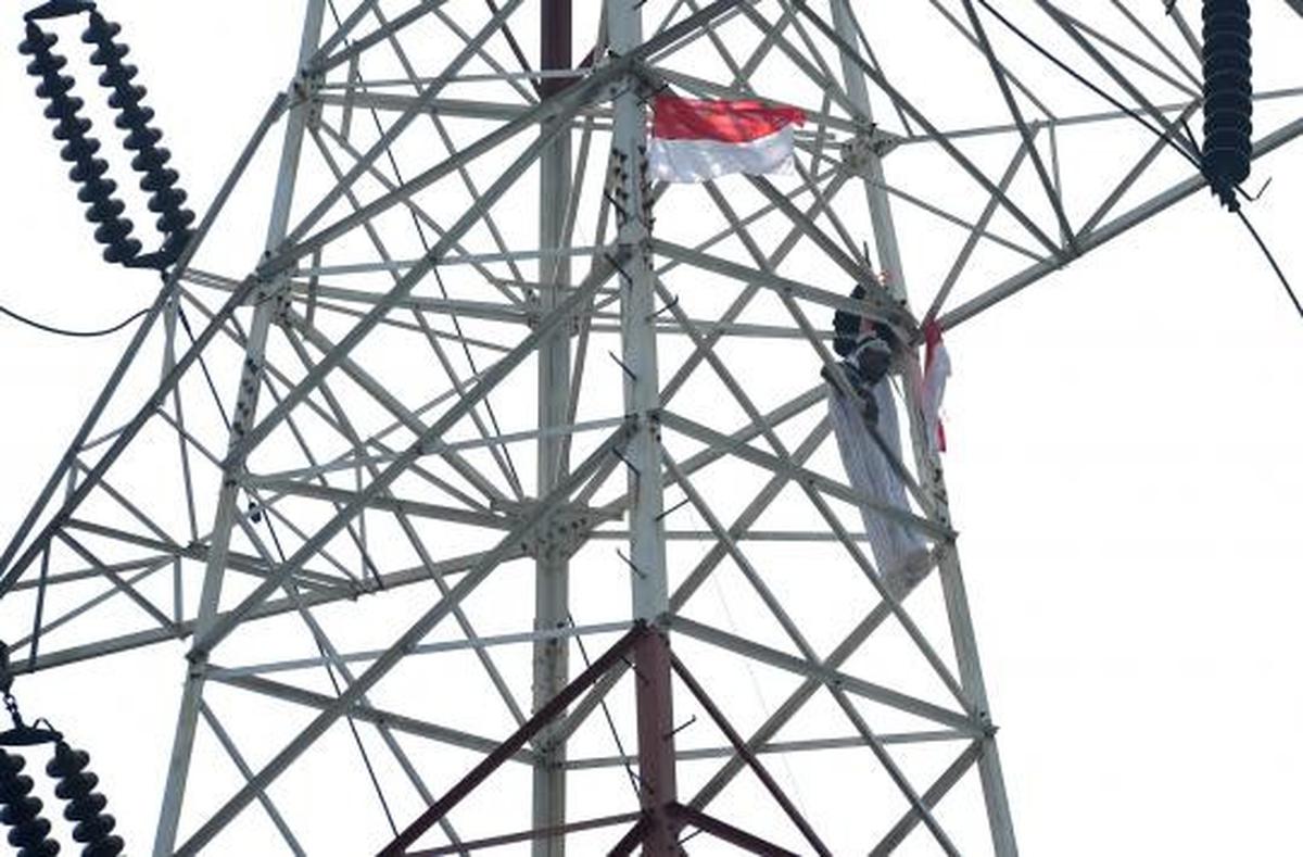 Pria berpakaian pocong di atas tower SUTET