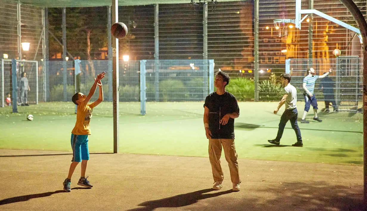 Sejumlah orang bermain bola basket di sebuah taman olahraga jalanan di Wina, Austria, Rabu (8/7/2020). Sejumlah orang di Wina pergi ke taman olahraga jalanan untuk melakukan olahraga luar ruangan setelah pembatasan COVID-19 dicabut. (Xinhua/Georges Schneider)