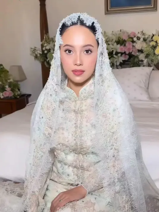 Gaunnya juga dilengkapi dengan tudung dari bahan lace senada. [@anggikabolsterli].