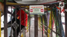 Seorang warga memanjat pagar Jembatan Penyeberangan Orang (JPO) yang menghubungkan daerah Rawajati dengan Cililitan di Jalan Raya Kalibata, Jakarta Selatan, Rabu (5/2/2025). (Magang/Liputan6.com/Muhammad Rizal)