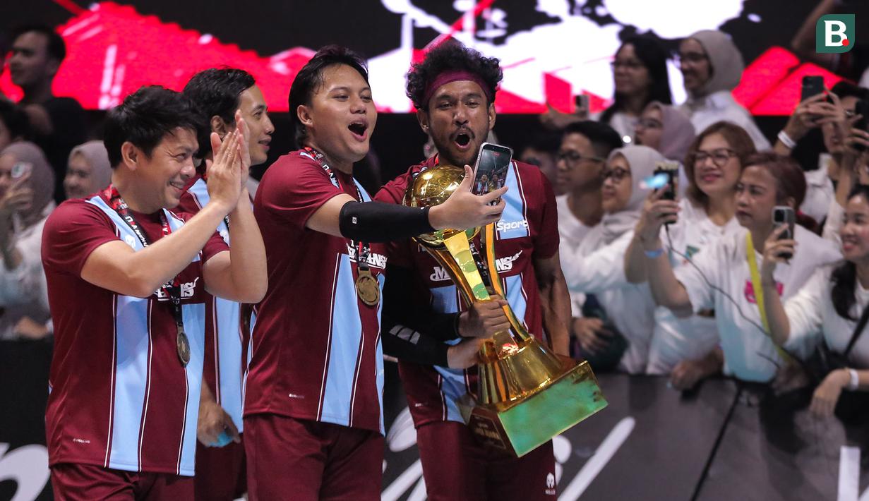 Para pemain The Musicians membawa piala saat merayakan kemenangan atas The Actors dalam laga Bahkan Voli 3 di Mahaka Square, Kelapa Gading, Sabtu (15 November 2025). (Bola.com/Internships/Monica Putri Salsabila)