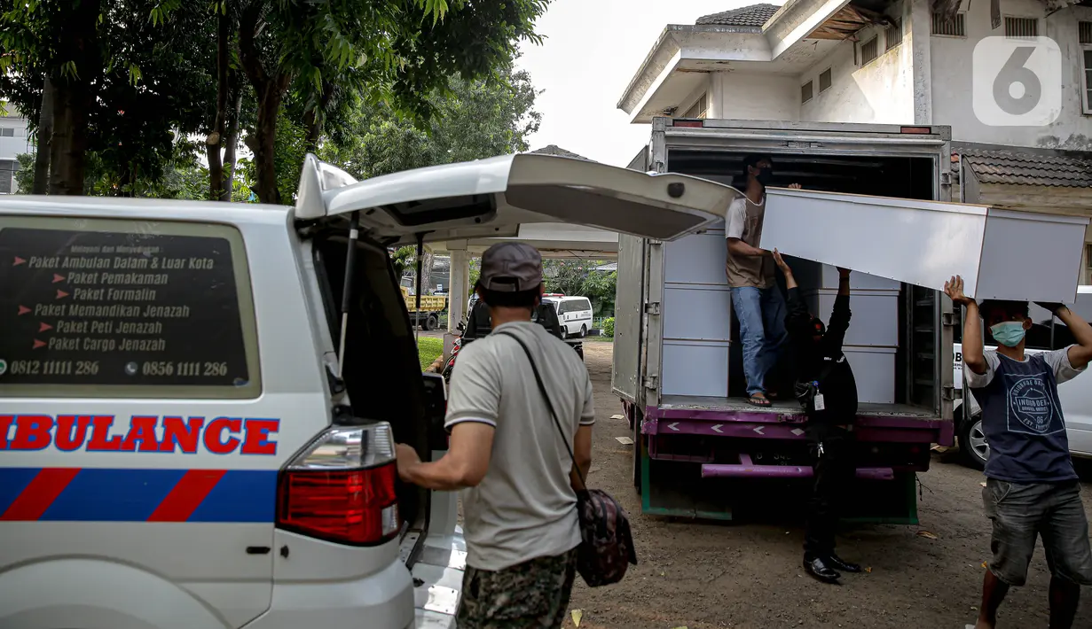 Petugas menurunkan peti jenazah COVID-19 untuk didistribusikan ke rumah sakit di TPU Petamburan, Jakarta, Selasa (6/7/2021). Pemprov DKI Jakarta melalui Dinas Pertamanan dan Hutan menyediakan peti jenazah gratis untuk rumah sakit dan pasien COVID-19 di seluruh DKI. (Liputan6.com/Faizal Fanani)