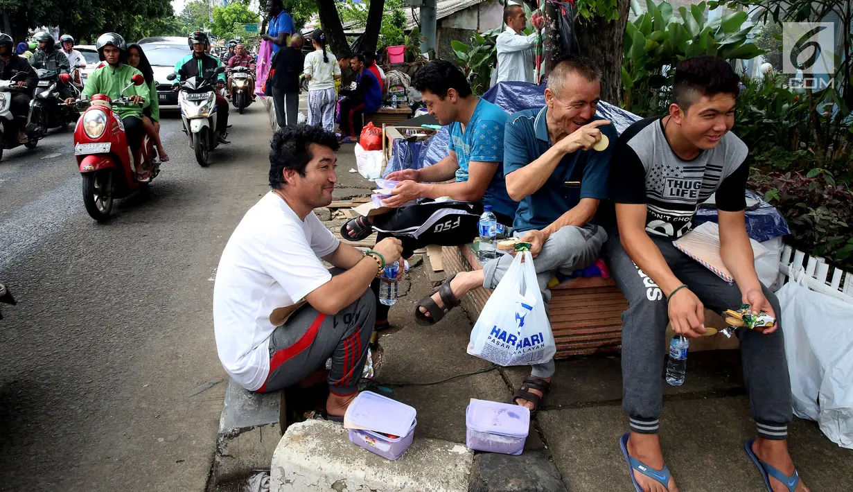 Para pencari suaka bercengkerama di trotoar depan Rumah Detensi Imigrasi Kalideres, Jakarta, Jumat (19/1). Selama 17 minggu, sebanyak 57 WNA tinggal di trotoar karena ruangan Rumah Detensi Imigrasi tersebut penuh. (Liputan6.com/JohanTallo)