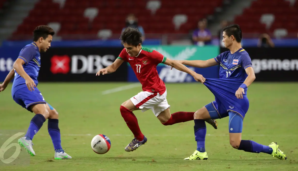 Gelandang timnas Indonesia U-23, Paulo Sitanggang (tengah) berusaha lolos dari kawalan dua pemain Thailand di semifinal sepak bola SEA Games ke-28 di National Stadium Singapore, Sabtu (13/6/2015). Indonesia kalah 0-5. (Liputan6.com/Helmi Fithriansyah)