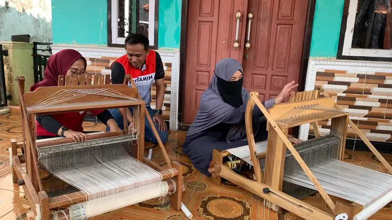 Sekelompok ibu-ibu tengah merajut kain di depan rumah di Desa Cikadu Subang. Benang rajutan tersebut berasal dari serat daun nanas.  (Gideon/Liputan6.com)