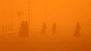 <p>Pejalan kaki menyeberang jalan di tengah badai debu parah di Kuwait City pada 23 Mei 2022. Badai pasir telah melanda Timur Tengah dalam beberapa hari terakhir, dan menjadi fenomena yang para ahli peringatkan dapat berkembang luas karena perubahan iklim. (Yasser Al-Zayyat / AFP)</p>