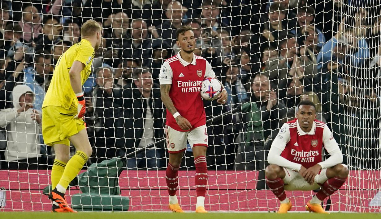 <p>Pemain Arsenal, Ben White, memungut bola setelah gawangnya dibobol Manchester City pada laga Liga Inggris di Stadion Etihad, Kamis (27/4/2023). The Gunners harus menelan pil pahit kala bertandang ke markas City. (AP Photo/Dave Thompson)</p>